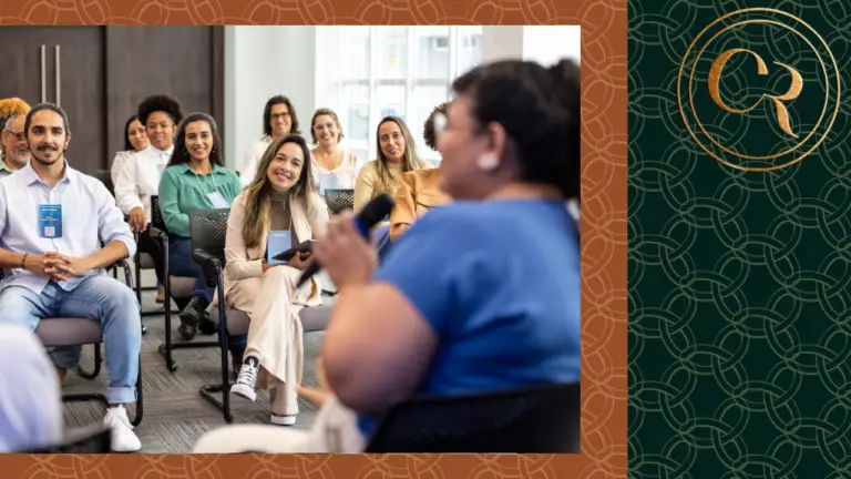 black woman in blue shirt delivering a company workshop to employees in a classroom